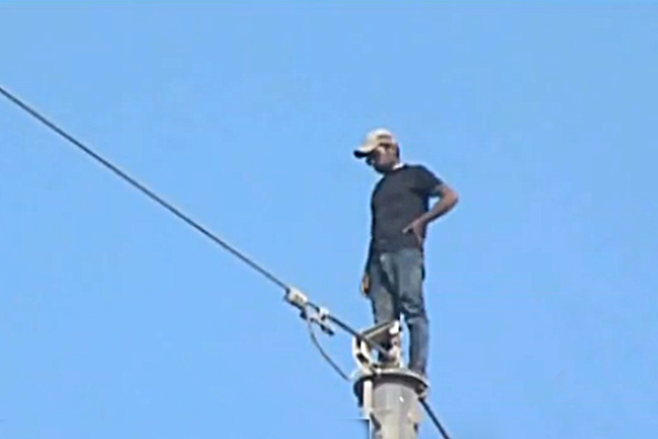 man climbed an electric pole
